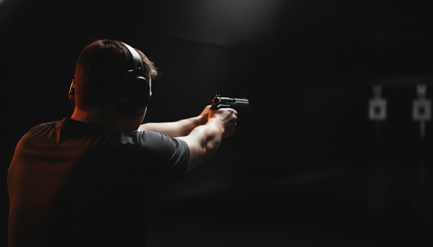 A shooter training with a pistol at an indoor range